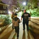 Students and police, walking, at night, on campus.