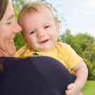 Mother holding baby who faces the camera