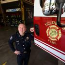 Fire Chief Nate Trauernicht poses next to firetruck.