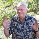 Tom Cahill, smiling, throwing hands up, at riparian preserve donation, May 2017.