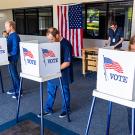 Voting booths with people voting