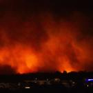 Plumes of fiery smoke from the Pacific Palisades Fire at night 