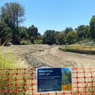 A dry lake with a fence around it