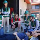 Six students perform first aid drill outside fire department