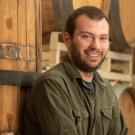 Man leans against stacked beer barrels