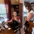 Researcher talks with older patient in her dining room