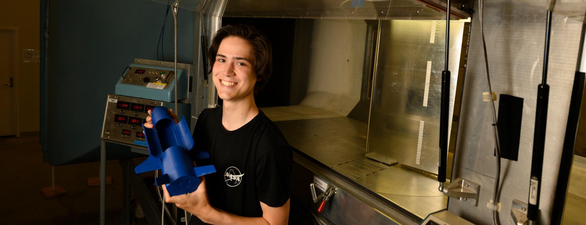 A male student holding a space shuttle model.