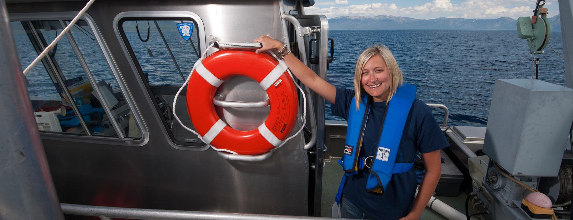 A female researcher poses on a research vessel on Lake Tahoe