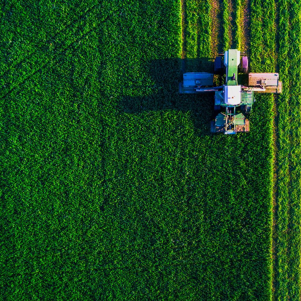 An overhead view of a combine working an agricultural field