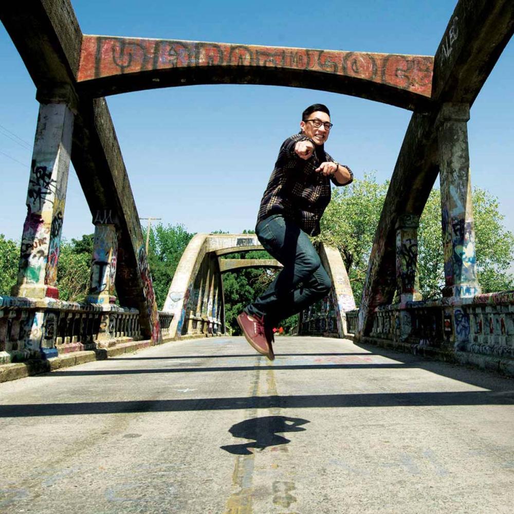 a student caught in mid-air leaping on a bridge