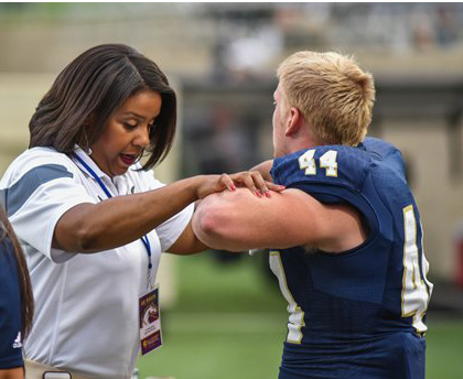 Woman conducting a balance test with a football player