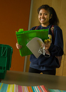 A female students chooses produce at Fruit & Veggie Up!.